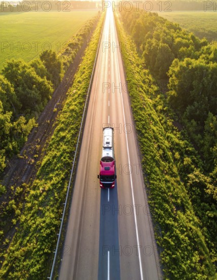 Petrol cargo truck lorry tanker driving on highway hauling oil products at sunrise, wide hilly