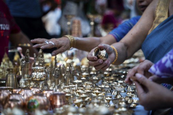 People shop for bronze and other metal items at a roadside stall on Dhanteras, in Guwahati, Assam,