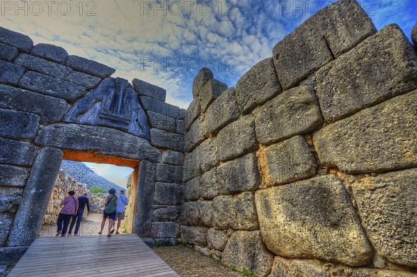 HDR, group of visitors passes through a huge stone gate, lion gate, Mycenae, archaeological site,