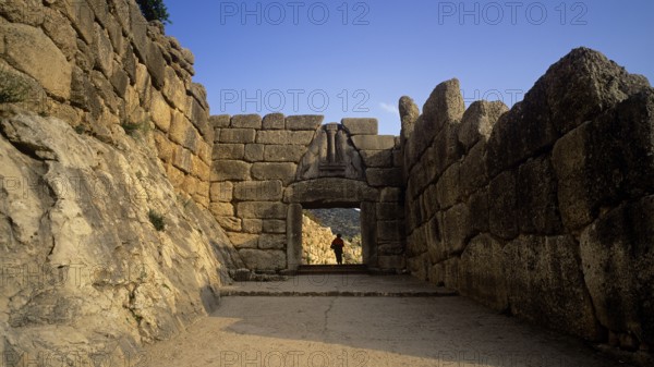 Single person standing in a huge stone gate, lion gate, Mycenae, archaeological site, UNESCO World