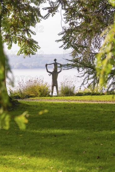 A statue in a park surrounded by trees and green grass with an autumnal atmosphere, Überlingen,