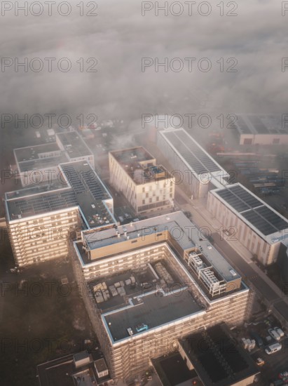 Urban industrial area seen from above in fog and dawn, new hospital health campus building, Calw,