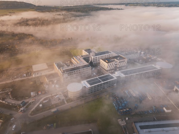 Bird's-eye view of industrial building group in mystical fog weather, new hospital health campus