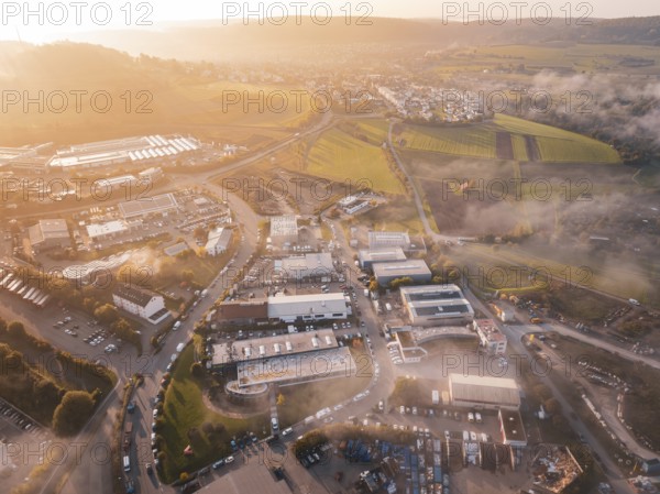 Sunrise over a village with adjacent fields and winding roads, new hospital health campus building,