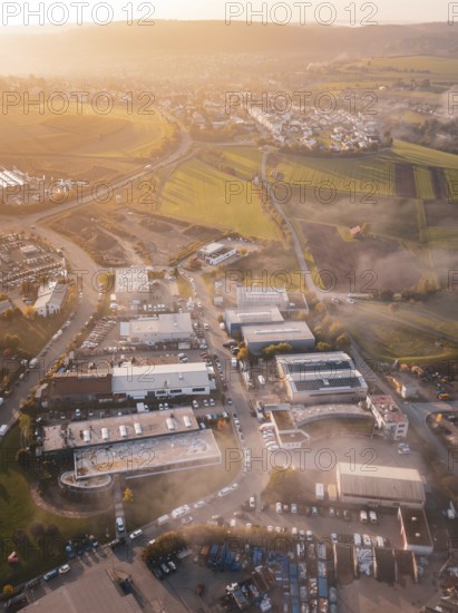 Aerial view of a village in morning light surrounded by rolling fields, new hospital health campus