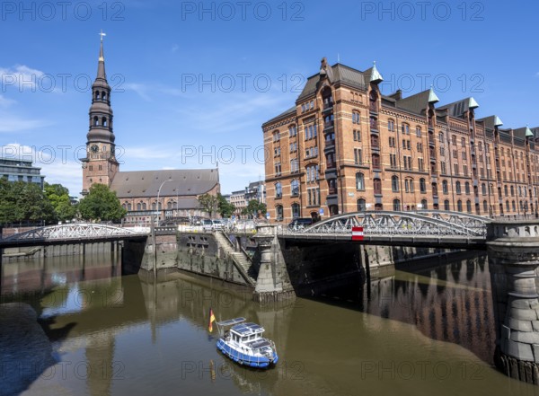 Boat on the Kleines Fleet canal with Kannengießer bridge and tower of the main church of St.