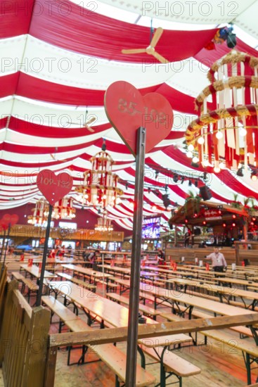 Festively decorated marquee with red blankets, wooden benches and heart-shaped sign, Cannstatter