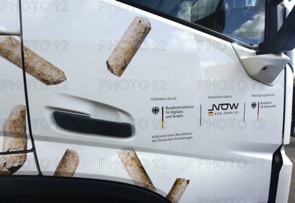 The passenger door of an electric lorry shows which state institutions have paid and approved