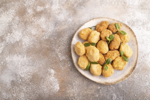 Fried crispy Chicken Nuggets with ketchup, microgreen on brown concrete background. top view, flat