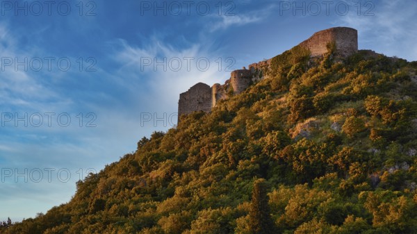 Byzantine castle from the 13th century AD, Ancient walls towering over a green, overgrown slope