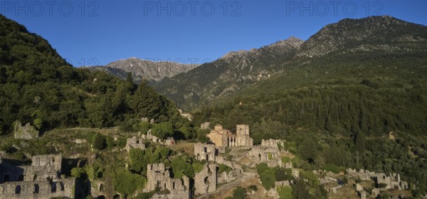 Drone shot, Ancient ruins in a mountainous and wooded environment in sunny weather, including the