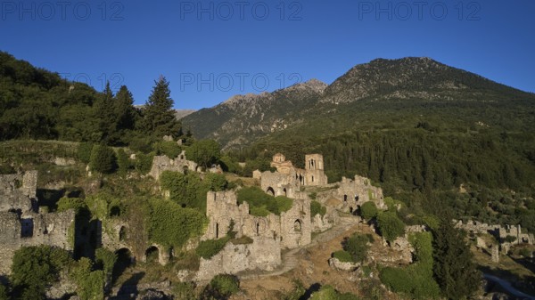 Drone shot, Historical ruins in a hilly landscape with a clear blue sky, Church of Agia Sophia from