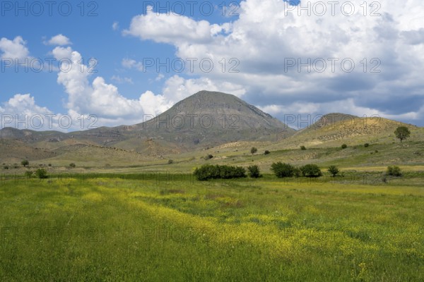 Mountain landscape with vast green and yellow fields under a cloudy sky, landscape near Shaghap,