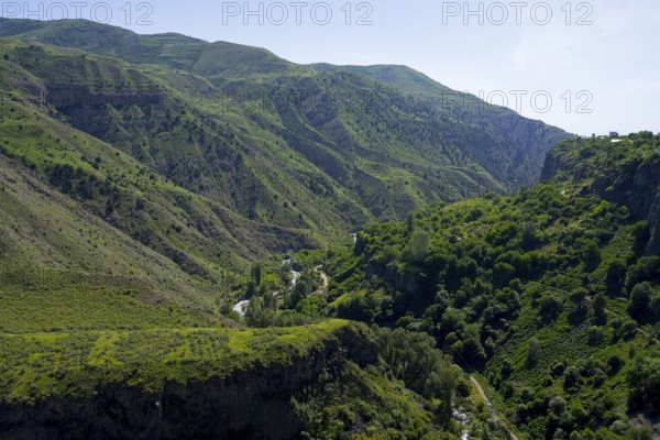Deep gorge with dense green vegetation and wooded slopes under a clear sky, Garni Gorge, Azat