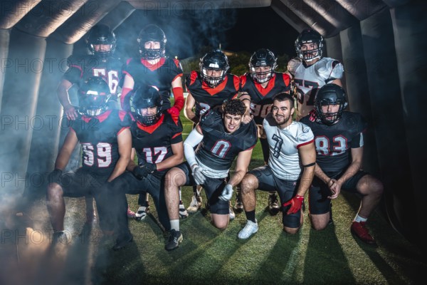 American football team poses united in helmets and pads, emerging from a smoky stadium tunnel under