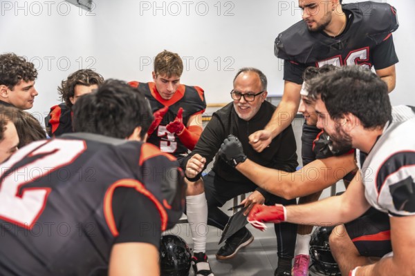 American football coach delivering a motivational speech to a diverse team of young players in