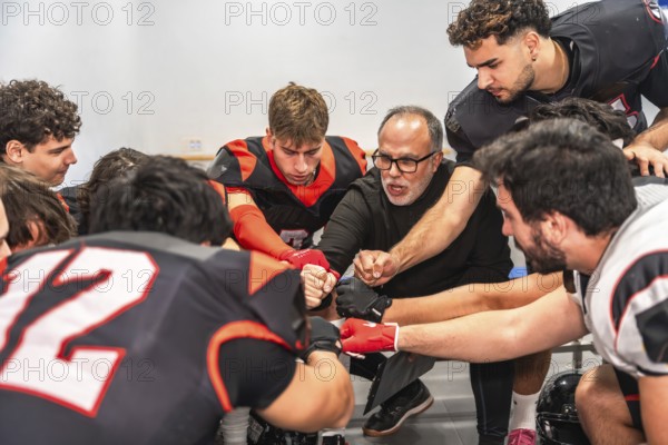 American football coach and players huddling in a locker room, getting motivated for a game while