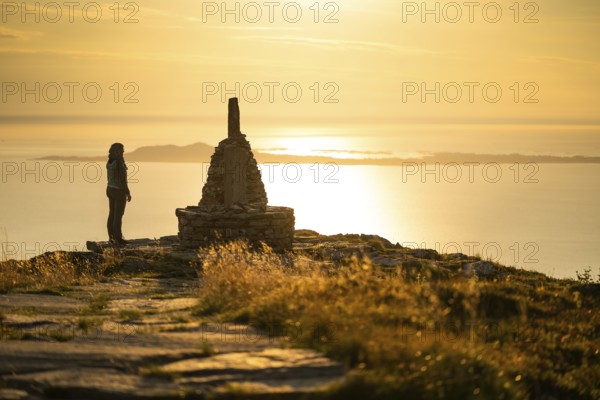 Woman standing next to cairn and looking at the sea, Rørsethornet stone staircase, with 3292 steps