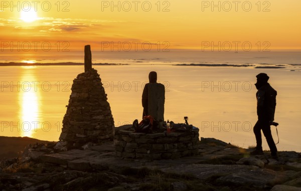 Silhouettes of two hikers next to cairns at sunset, Rørsethornet stone staircase, with 3292 steps