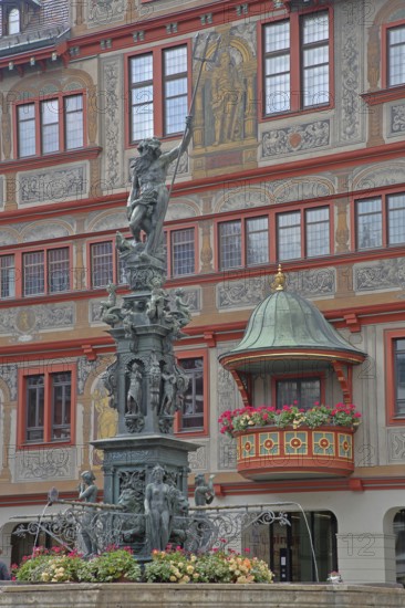 Neptune fountain with sculpture of Neptune Roman god of the sea with trident on the house facade