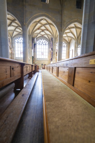 Bright church interior with long wooden benches, Gothic windows and vaulted ceiling, St Nicholas