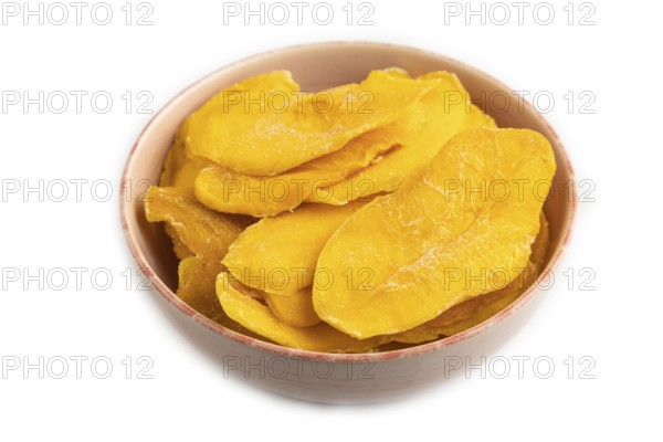 Dried Mango in ceramic bowl isolated on white background. Side view, close up, flat lay. healthy