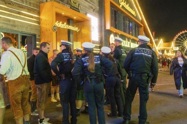 Police officers monitor the marquee area at night and ensure safety among the visitors, Cannstatter