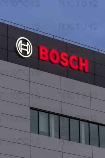 Tall grey building façade with Bosch logo and large windows at night, Waiblingen,
