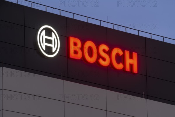 Illuminated Bosch logo on a grey façade against a blue night sky, Waiblingen, Baden-Württemberg,