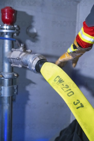 Fire hose being connected to hydrant, close-up of the connection, fire brigade exercise in the new