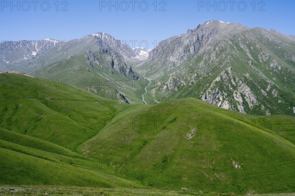 Green hills and majestic mountains under a clear blue sky, at the highest pass in Armenia, Meghri