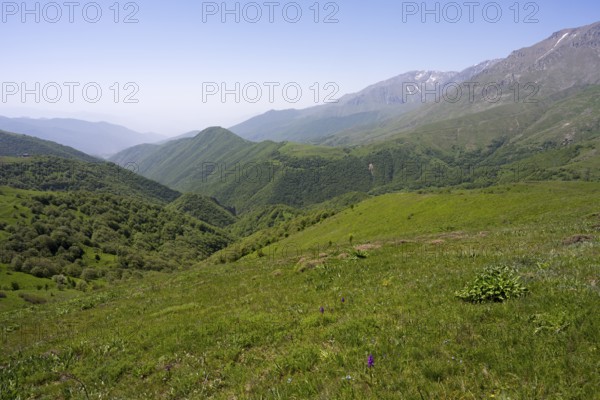 Green valley with hills and mountains under a wide sky, at the highest pass in Armenia, Meghri