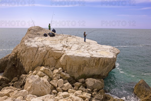 Angler, fishing, rocky plate, south at the rock Penon de Ifach landmark, Mediterranean Sea, bay,