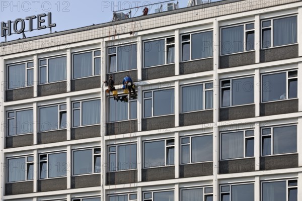 Two male glass cleaners abseiling down the hotel façade to clean windows, aletto Hotel Kudamm,