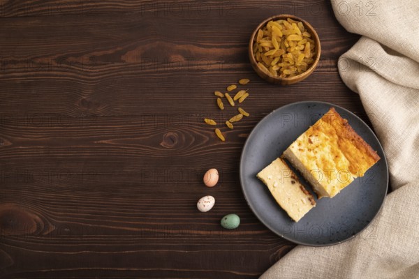 ?ottage cheese ?asserole, Curd cake, with dried apricots and raisins on brown wooden background and