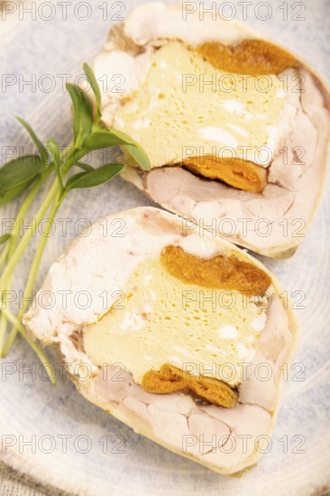 Chicken, egg and dried apricot meatloaf, microgreen on brown concrete background and linen textile.