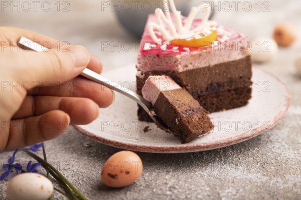 Chocolate cake with hand on brown concrete background, cup of coffee, side view, close up,