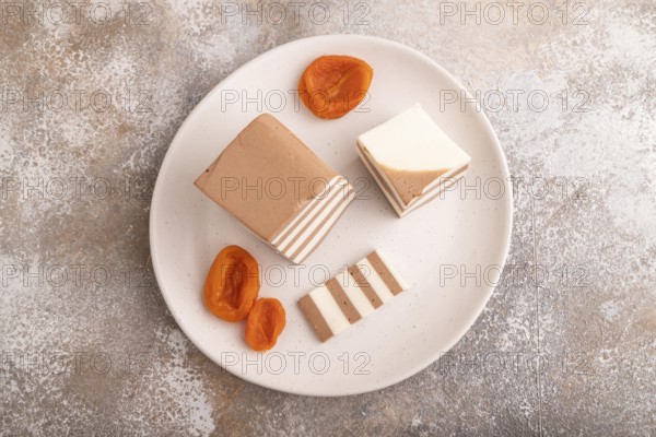 Cocoa and milk jelly with dried apricots on brown concrete background, top view, flat lay, copy