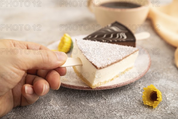 Chocolate and Vanilla Cake pops Marshmallow with hand with cup of coffee on brown concrete