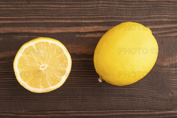 Yellow Lemon Cut in half on brown wooden background. Top view, flat lay, close up. healthy food,