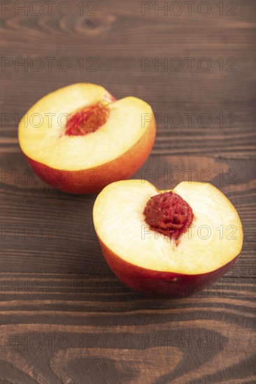 Peach Cut in half on brown wooden background. Side view, flat lay, close up. healthy food,