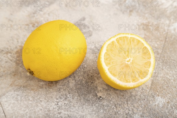 Yellow Lemon Cut in half on brown concrete background. Side view, close up, healthy food,