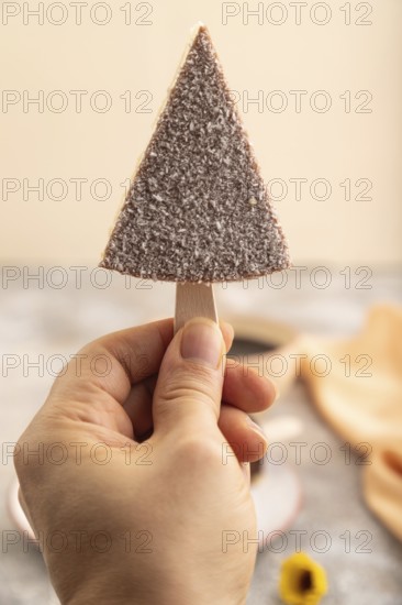 Chocolate and Vanilla Cake pops Marshmallow with hand with cup of coffee on brown concrete