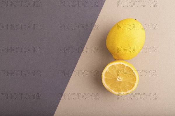 Yellow Lemon Cut in half on beige and gray pastel paper background. Top view, flat lay, copy space.
