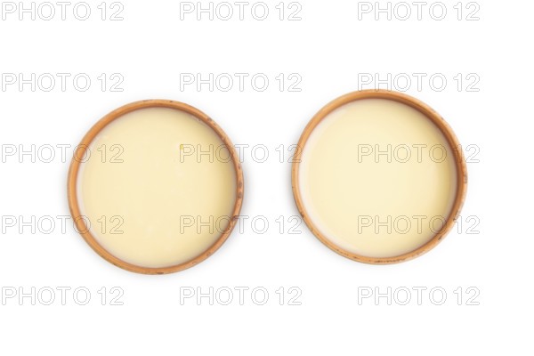 Organic non dairy banana and soy milk in clay cup isolated on white background. Vegan healthy food
