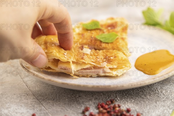 Fried homemade Khachapuri cake with hand with cheese and meat, fried in pan. Traditional Georgian
