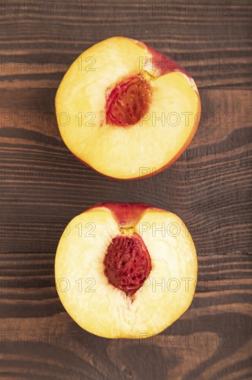Peach Cut in half on brown wooden background. Top view, flat lay, close up. healthy food,