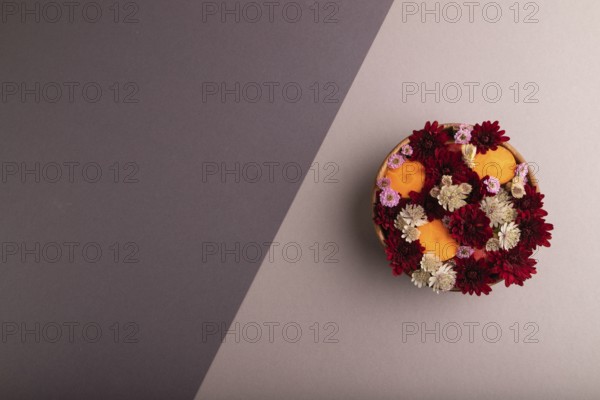 Wooden bowl with carrot slices and red Chrysanthemum flowers, Astrantia flowers, flower salad on
