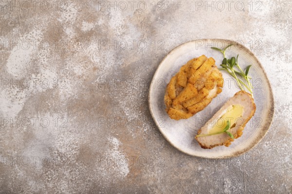 Chicken schnitzel on blue plate with microgreen on brown concrete. Diet, healthy eating. top view,