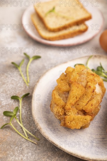 Chicken Schnitzel on blue plate with microgreen on brown concrete background and orange linen